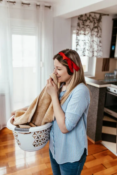 Vacker Ung Leende Kvinna Luktar Rena Handdukar Medan Tvättar Hemma — Stockfoto