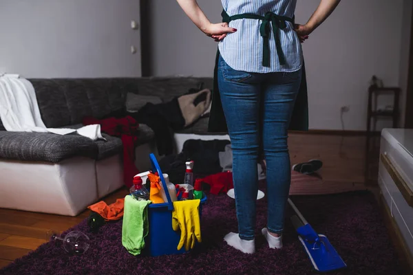 Trött Ung Kvinna Står Vardagsrummet Med Rengöringsmedel Och Utrustning Hushållsarbete — Stockfoto