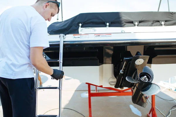 Tekne bakımı, kumaşla tekne temizleyen bir adam. Seçici odak.