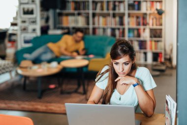 Kitapçıda kitap seçen çekici genç kız öğrenci.