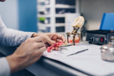 Diş protezi, protez. Takma dişler üzerinde çalışırken protez ellerini kapat. Seçici odak.