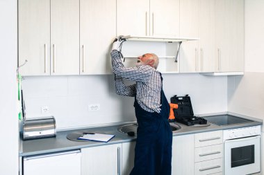 Mutfakta çalışan usta bir tamirci. Yenileme.