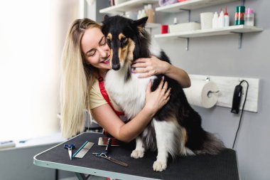 Kadın kuaför, kuaföründe Rough Collie ile poz veriyor..