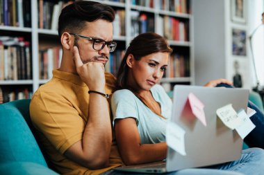 Üniversite kütüphanesinde oturan çekici genç öğrenci erkek ve kadın.. 