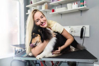 Kadın kuaför, kuaföründe Rough Collie ile poz veriyor.. 
