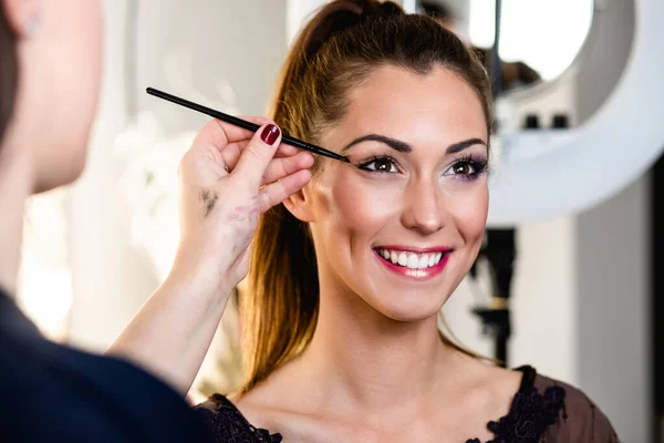 Make Artysta Robi Profesjonalny Makijaż Pięknej Młodej Kobiecie — Zdjęcie stockowe