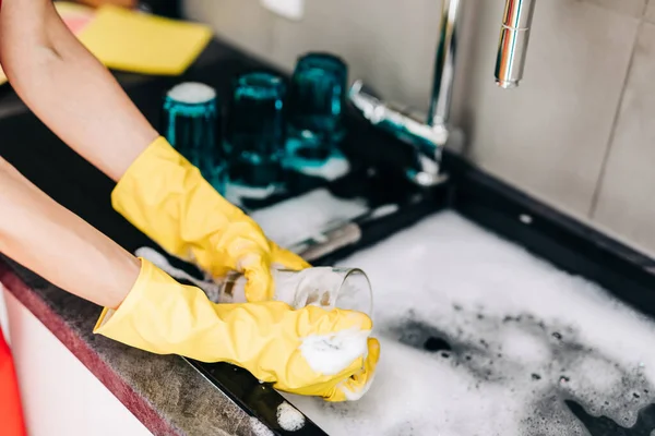 黄色の保護ゴム手袋で女性の手の閉じるキッチンで食器洗い — ストック写真