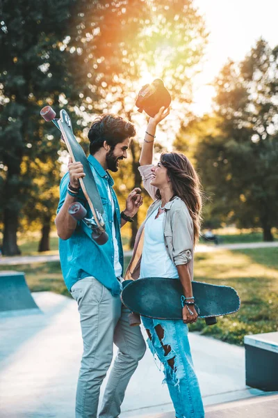 市内スケートパークでアウトドアを楽しむ美しい若いカップル — ストック写真