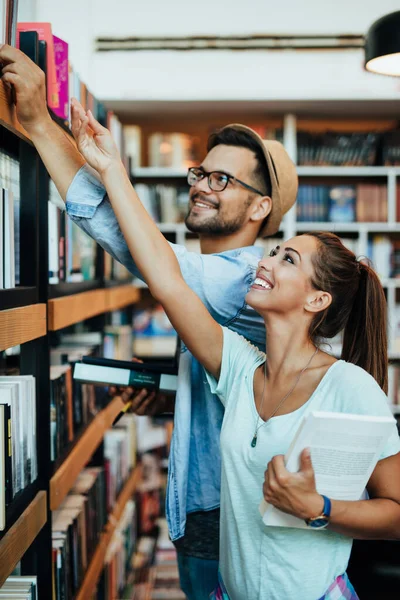 書店で本を選ぶ魅力的な若い学生の男と女 — ストック写真