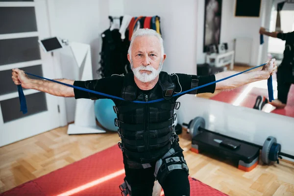 Симпатичный Позитивный Пожилой Человек Делает Упражнения Костюме Электрической Мышечной Стимуляции — стоковое фото