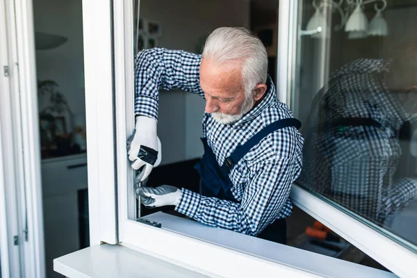 Starší Údržbář Opravuje Okno Renovace — Stock fotografie