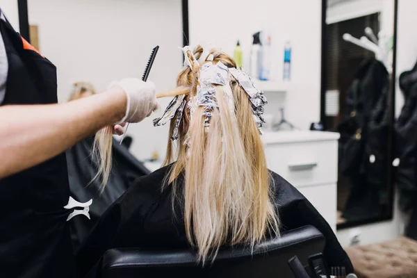 美容師は女性の髪を死んでいる 箔で彼のクライアントに髪のハイライトを作る — ストック写真