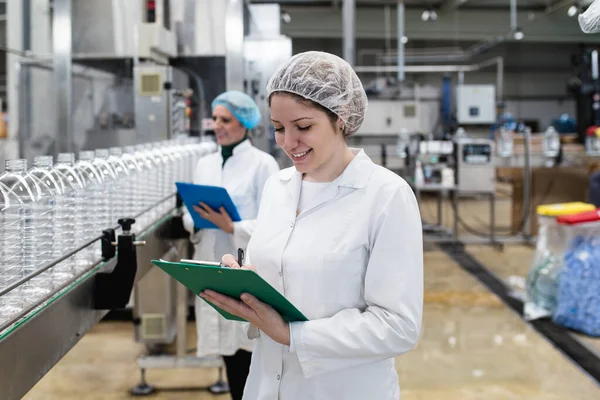 Vrouwelijke Werknemers Bottelfabriek Controleren Waterflessen Voor Verzending Inspectiekwaliteitscontrole — Stockfoto