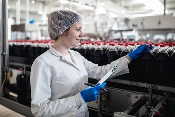 Pekerja Wanita Muda Yang Bahagia Pabrik Pembotolan Memeriksa Botol Jus Stok Gambar