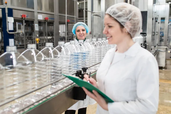 Pekerja Wanita Pabrik Pembotolan Memeriksa Botol Air Sebelum Pengiriman Kontrol Stok Gambar Bebas Royalti
