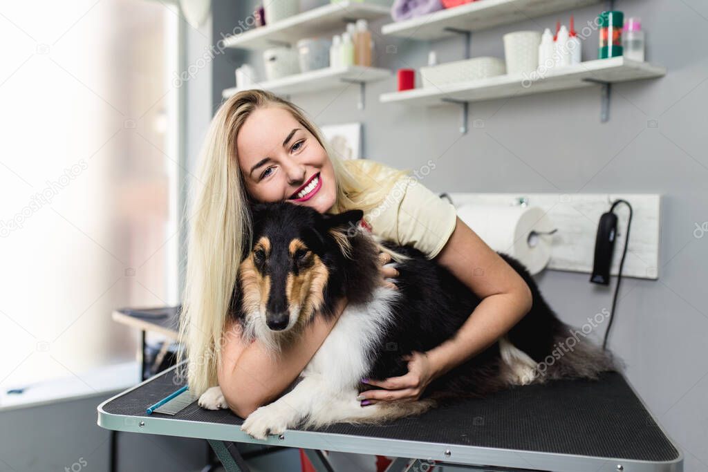 Female groomer posing with Rough Collie in her grooming salon.
