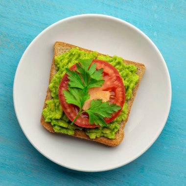 Avokado tost siyah susam ve biber ve domates bir dilim kepek ekmek imal.