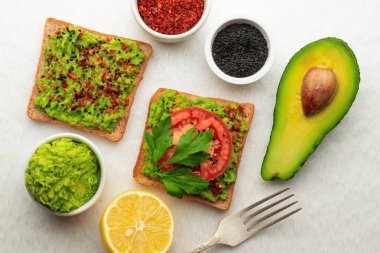 Siyah susam ve biber ve domates bir dilim ile tatlandırılmış avokado tost.