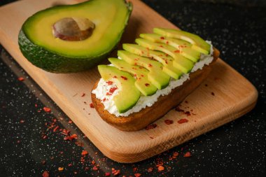 İştah açıcı avokado ekmek peynir ve yarım bir mango meyve kesme tahtası.