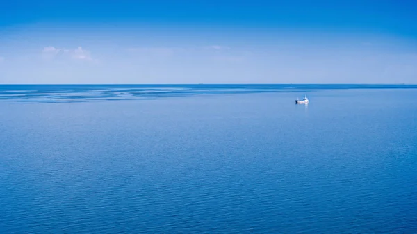 蓝色的大海和天空 远处的一艘孤独的船 — 图库照片