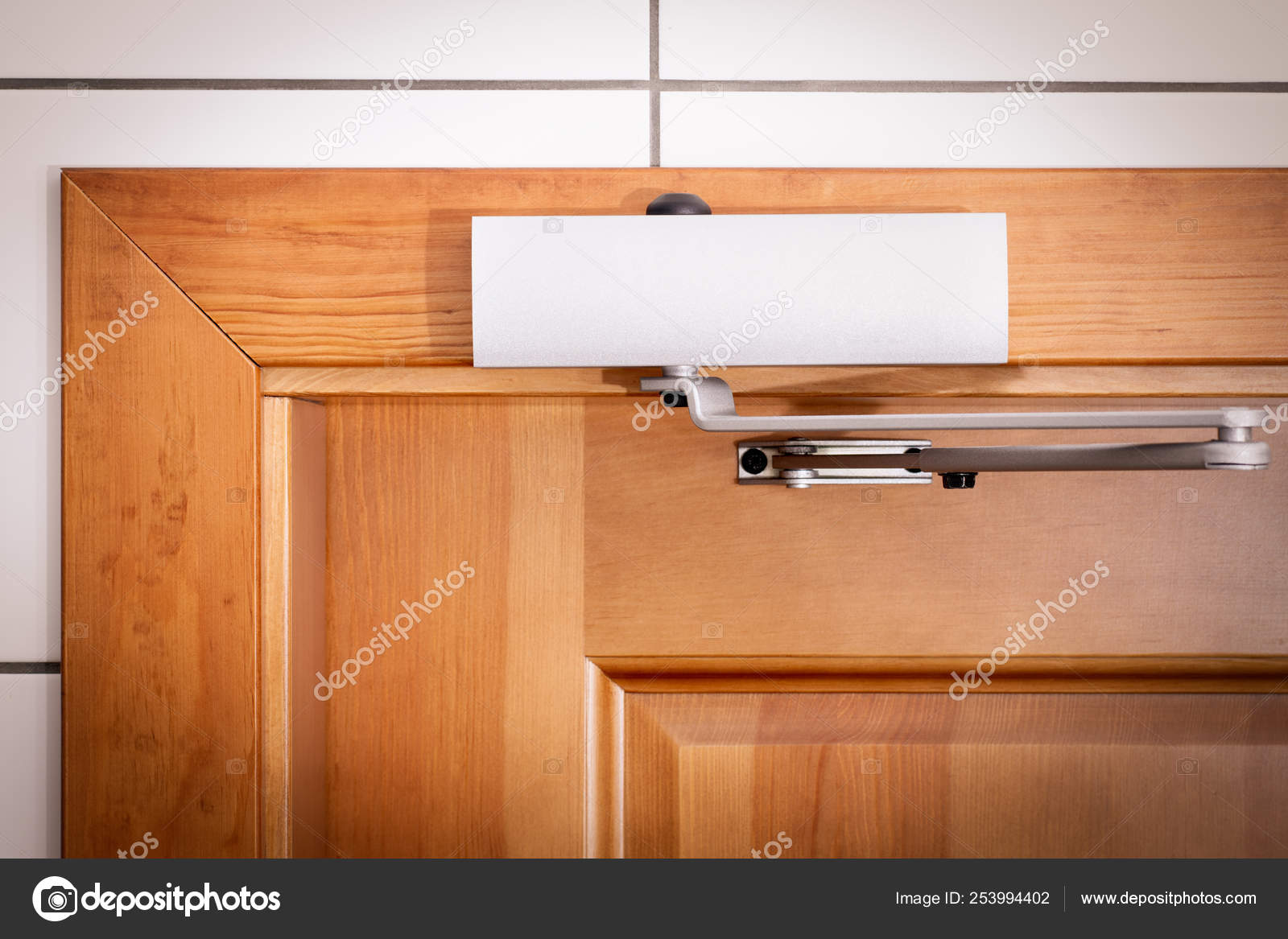 Door closers with lever on a wooden door made of pine Stock Photo by