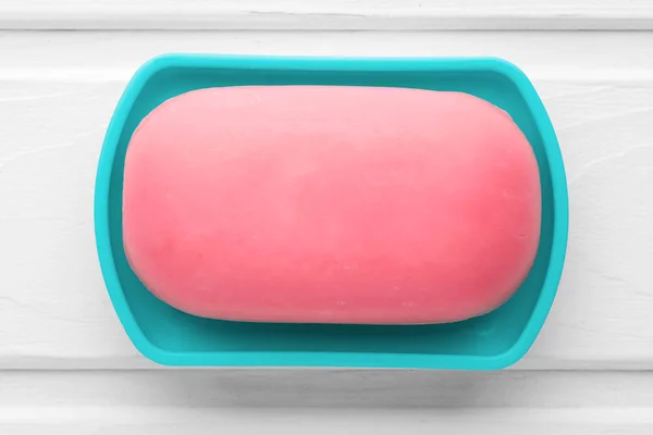 Pink soap in a blue soap dish on a white wooden background — Stock Photo, Image