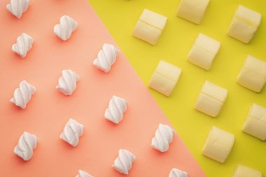 Üst görünüm sarı ve pembe arka planda farklı renk marshmallows