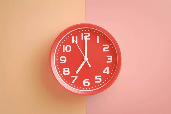 베이지 핑크 배경에 7시를 보여주는 빨간 시계 — 스톡 사진