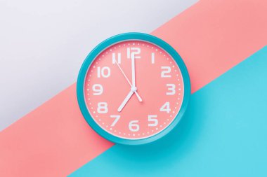 Malzeme tasarımı tarzında renkli bir arka plan üzerinde yuvarlak kadranlı çalar saat