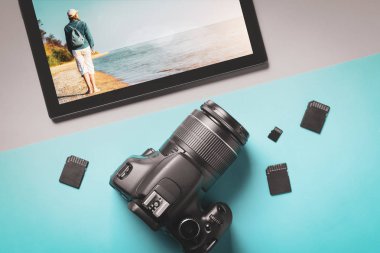 Deniz tarafından genç bir kadının fotoğrafları ile üst görünüm modern kamera ve tablet