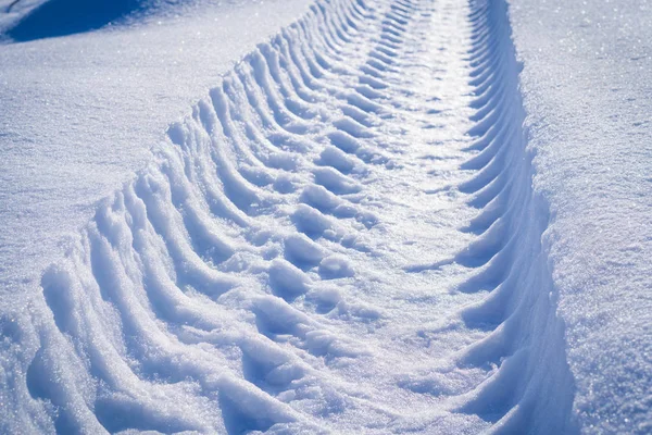 Pista de la pisada de una rueda de coche en la nieve en un día helado —  Fotos de Stock