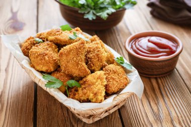 Ev yapımı tavuk nugget sepetinde ahşap arka planda..