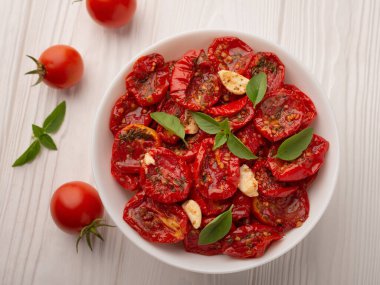 Tahta arka planda güneşte kurutulmuş domates kasesinin üst görüntüsü..