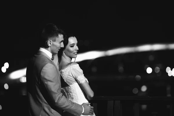 Este séta a fiatal esküvő házaspár a híd a krakkói. Fekete-fehér fénykép beállítást — Stock Fotó