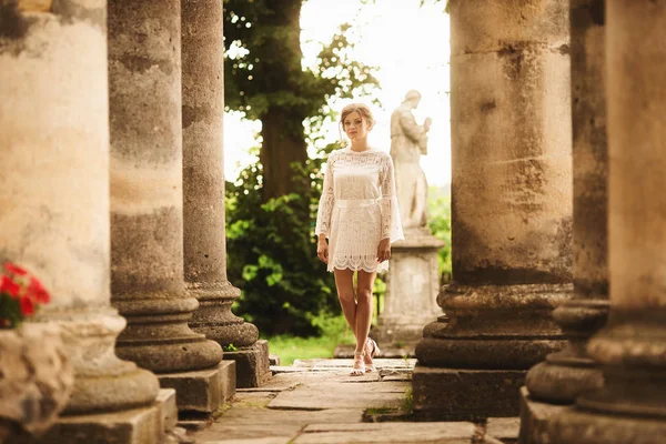 Una maravillosa historia de amor. Pareja joven caminando alrededor de las viejas columnas arquitectónicas — Foto de Stock