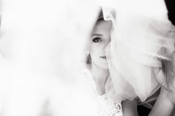 Hermoso estilo de novia. Boda chica de pie en vestido de novia de lujo cerca de la ventana. Blanco y negro — Foto de Stock