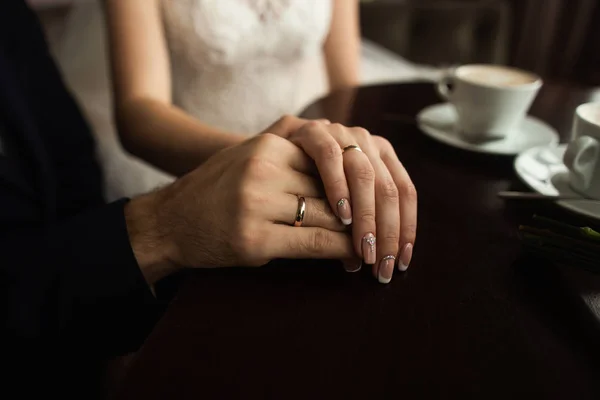 Hände frisch vermählter Paare mit goldenen Eheringen — Stockfoto