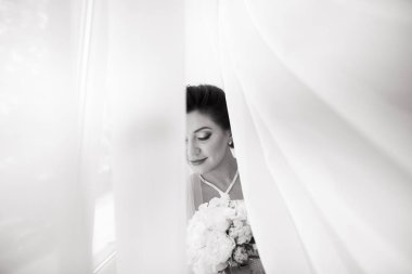 Perde altında poz beyaz elbiseli güzel seksi gelin