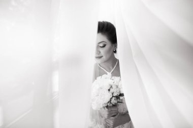 Perde altında poz beyaz elbiseli güzel seksi gelin