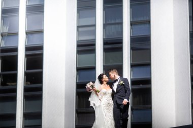 Gelin ve damat şehirde yürüyüş, düğün günü, evlilik kavramı. Gelin ve damat kentsel arka planda. Düğün gününde genç çift.