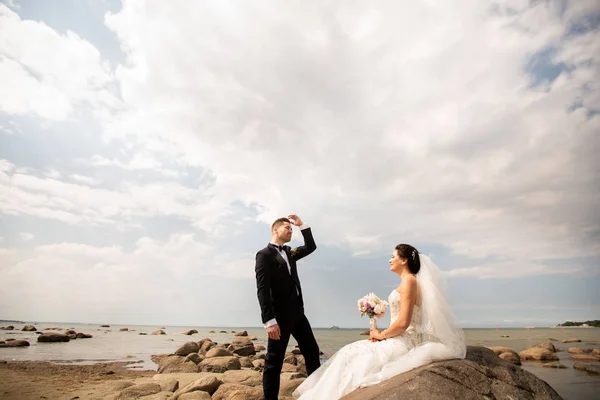 Stilvolles Hochzeitspaar am Ufer des Meeres. Frischvermählte spazieren am Meer — Stockfoto