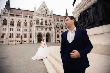 Gelin ve damat eski kasaba sokakta sarılmak. Düğün çift Budapeşte 'de Parlamento Evi yakınında yürüyor.