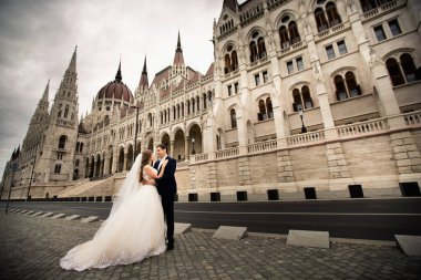 Gelin ve damat eski kasaba sokakta sarılmak. Düğün çift Budapeşte 'de Parlamento Evi yakınında yürüyor.