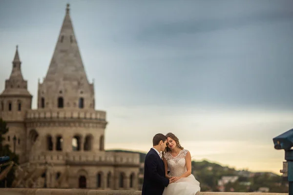 Young beautiful stylish pair of newlyweds sitting by the Fisherman 's Bastion in Budapest, Hungary — стоковое фото