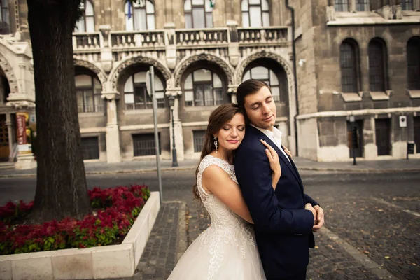 Menyasszony és vőlegény átölelve a régi város utcán. Házasodó pár szerelmes. Budapesti gyomirtás — Stock Fotó