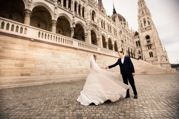 Gelin ve damat eski kasaba sokakta sarılmak. Düğün çift Budapeşte 'de Parlamento Evi yakınında yürüyor.
