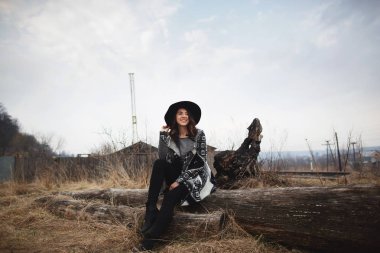 Ahşap bir tahta üzerinde oturan güzel kız. Kadınlar doğa ile mutlu hissediyorum