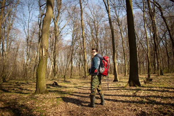 Anak muda dengan ransel hiking di hutan. Konsep alam dan latihan fisik — Stok Foto