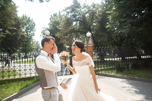 Pengantin pria dan wanita di hari pernikahan berjalan di taman yang indah, tersenyum berakhir menikmati satu sama lain — Stok Foto