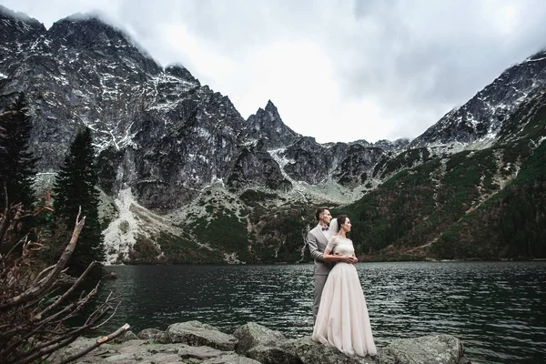 Joven pareja de novios posando en la orilla del lago Morskie Oko. Polonia, Tatra — Foto de Stock